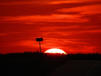 Silhouette landscape against orange sky