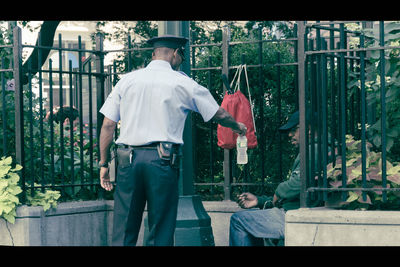 Rear view of men standing by railing