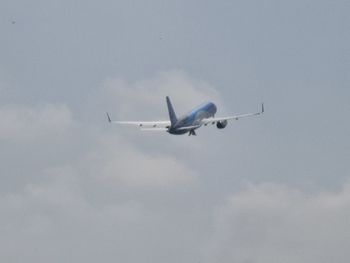 Low angle view of airplane flying against sky