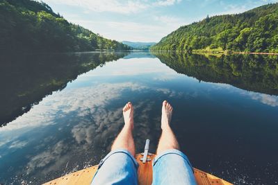 Low section of man on lake against sky