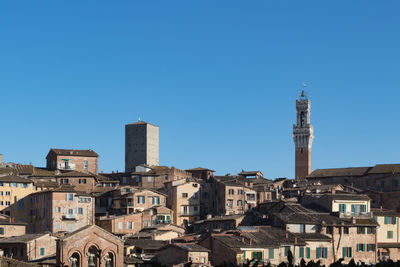 Buildings in city against blue sky