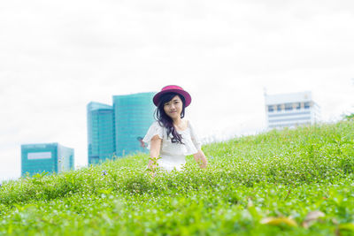 Portrait of young woman against plants against sky