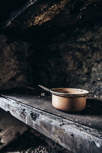 Abandoned lonesome copper pot left behind on an old wooden shelf in a lost place on corsica island.