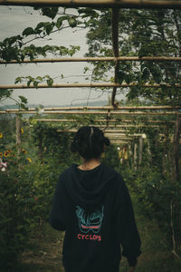 Rear view of teenage girl standing in forest