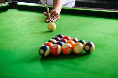 Midsection of man playing pool