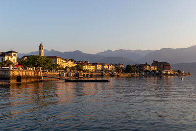 River by buildings against clear sky