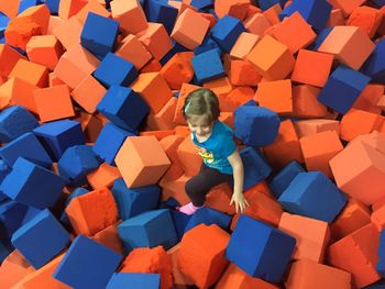 High angle view of girl playing on cube shape sponge