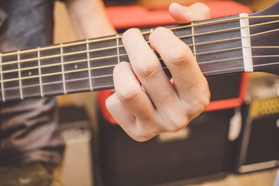 Midsection of person playing guitar