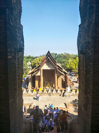 Group of people in front of historical building against clear sky