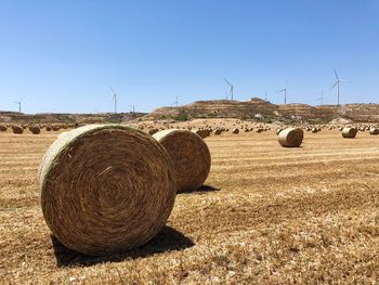 Hay bales on field against sky