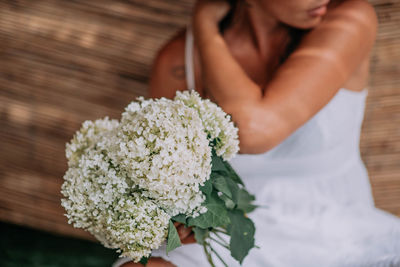 Midsection of woman with pink flower