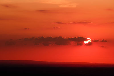 Scenic view of silhouette land against romantic sky at sunset