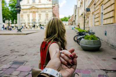 Travel in famous city follow me, girlfriend leading way in european city holding hand of boyfriend 