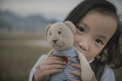 Close-up portrait of cute girl holding teddy bear