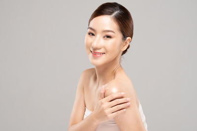 Portrait of young woman against white background