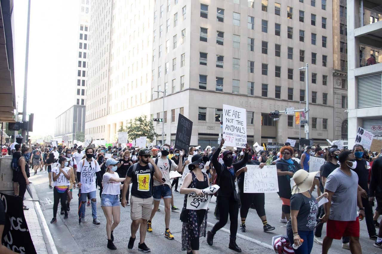 PEOPLE ON CITY STREET AGAINST BUILDINGS