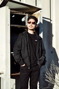 Portrait of young man wearing sunglasses standing outdoors