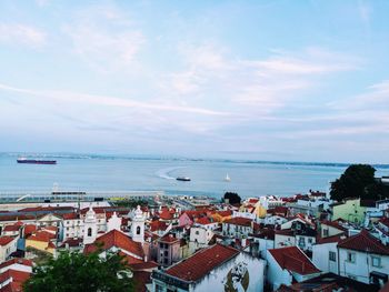 High angle view of townscape by sea against sky