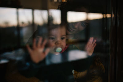 Woman with baby girl seen through glass window