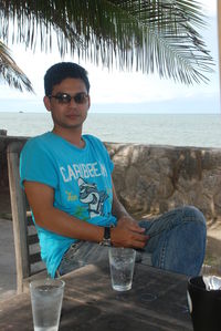 Portrait of young man wearing sunglasses at beach