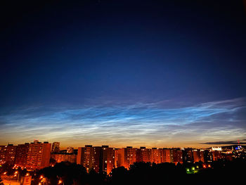 Illuminated city against sky at night