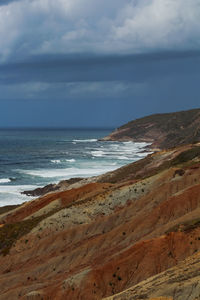 Scenic view of portugal wild beach with cliffs against sky