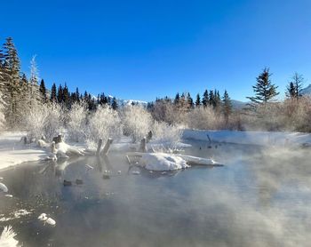 Scenic view of frozen lake against blue sky