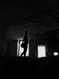 Silhouette man standing in abandoned building