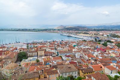 High angle view of townscape by sea against sky