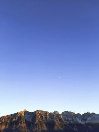 Scenic view of mountains against clear blue sky