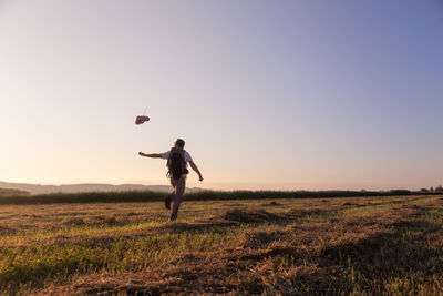 Full length of man standing on field against sky during sunset