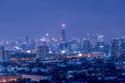 Illuminated cityscape against sky at night