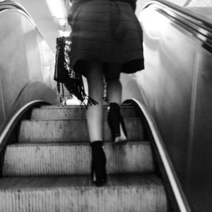 Woman standing on escalator