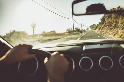 Midsection of person seen through car windshield