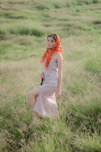 Young woman standing on grassy field