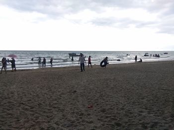 People on beach against sky