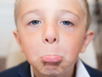 Close-up portrait of cute boy making face