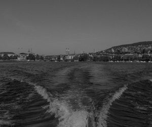 Scenic view of sea and buildings against clear sky