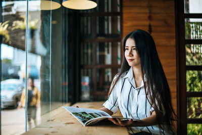 Young woman sitting on book