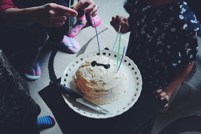 High angle view of father celebrating son birthday with cake in plate on table