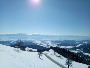 Scenic view of snow covered mountains against blue sky