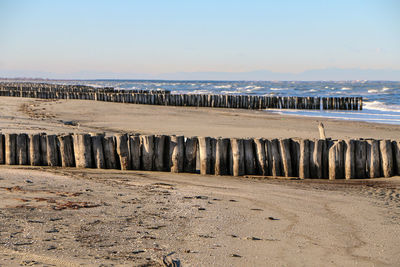 Groyne on beach against sky