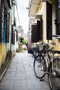 Bicycles parked on street amidst buildings in vietnam