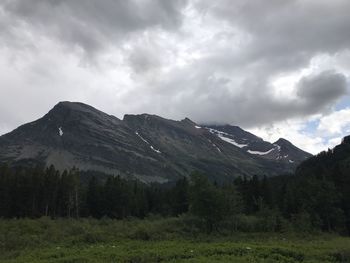 Scenic view of mountains against cloudy sky