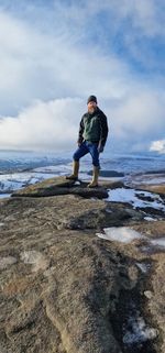Rear view of woman walking on beach against sky