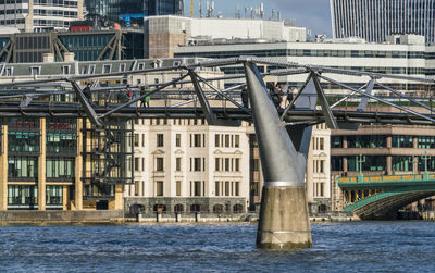 Bridge over river by buildings in city