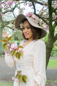 Portrait of young woman with flowers on tree