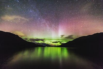 Scenic view of lake against sky at night