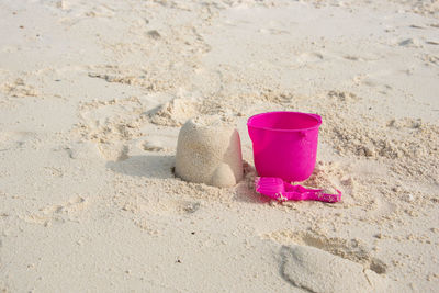 Close-up of pink toy on sand at beach