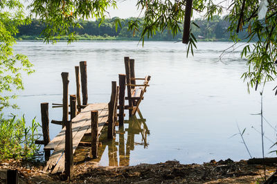 Wooden posts on beach by lake